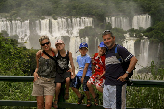 family-trip-exploring-iguazu-falls A family possing in front of the Iguazú Falls!