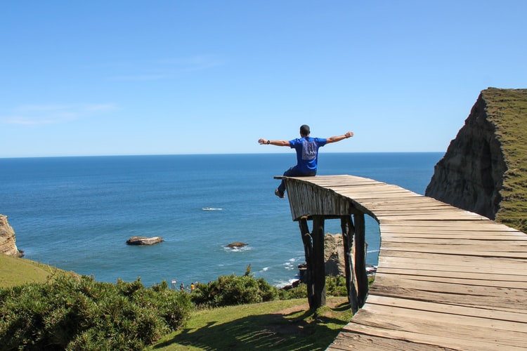 chiloe-chile-lakes Man with open arms at the pier in Chiloé, Chile.