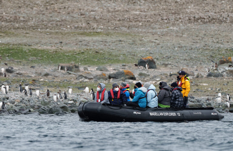 zodiac-navigation-in-antarctica Spoting penguins on the coast in a Zodiac boat, Antarctica.